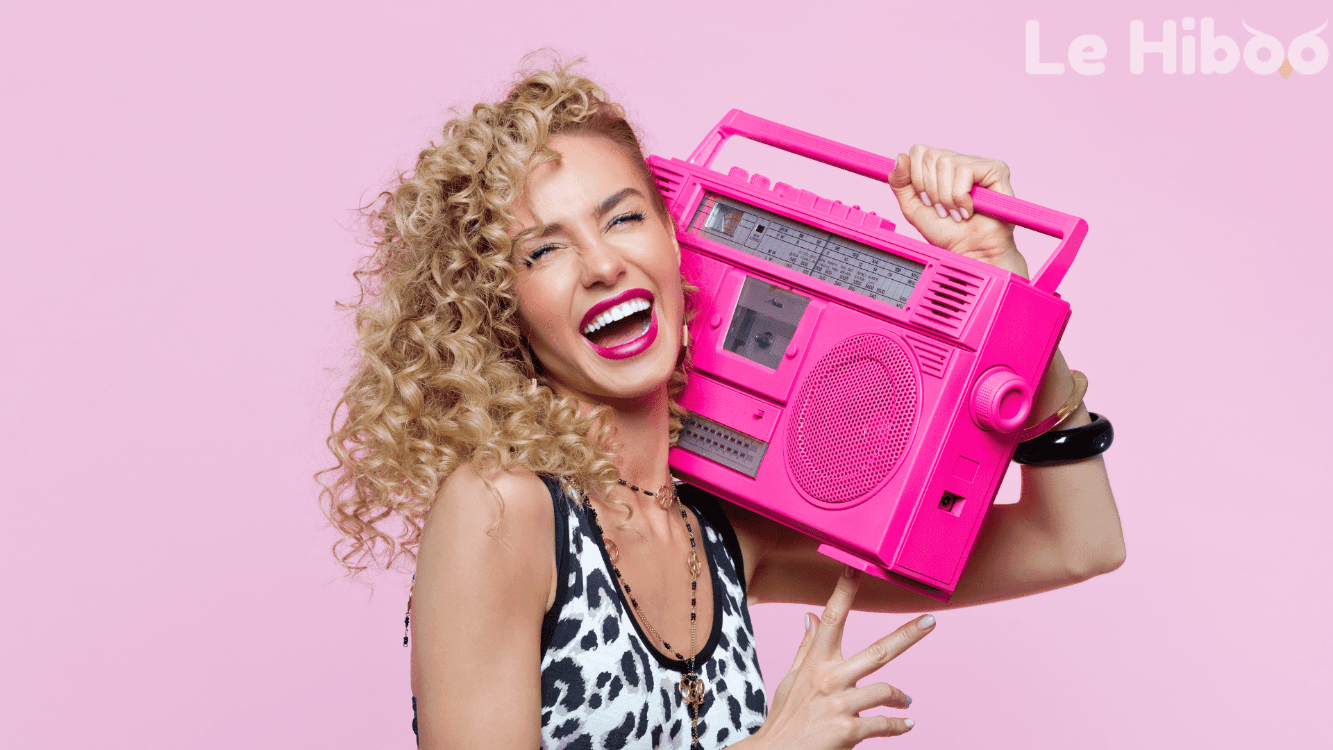 Femme année 80 écoutant un grosse radio rose sur fond rose Femme année 80 écoutant un grosse radio rose sur fond rose
