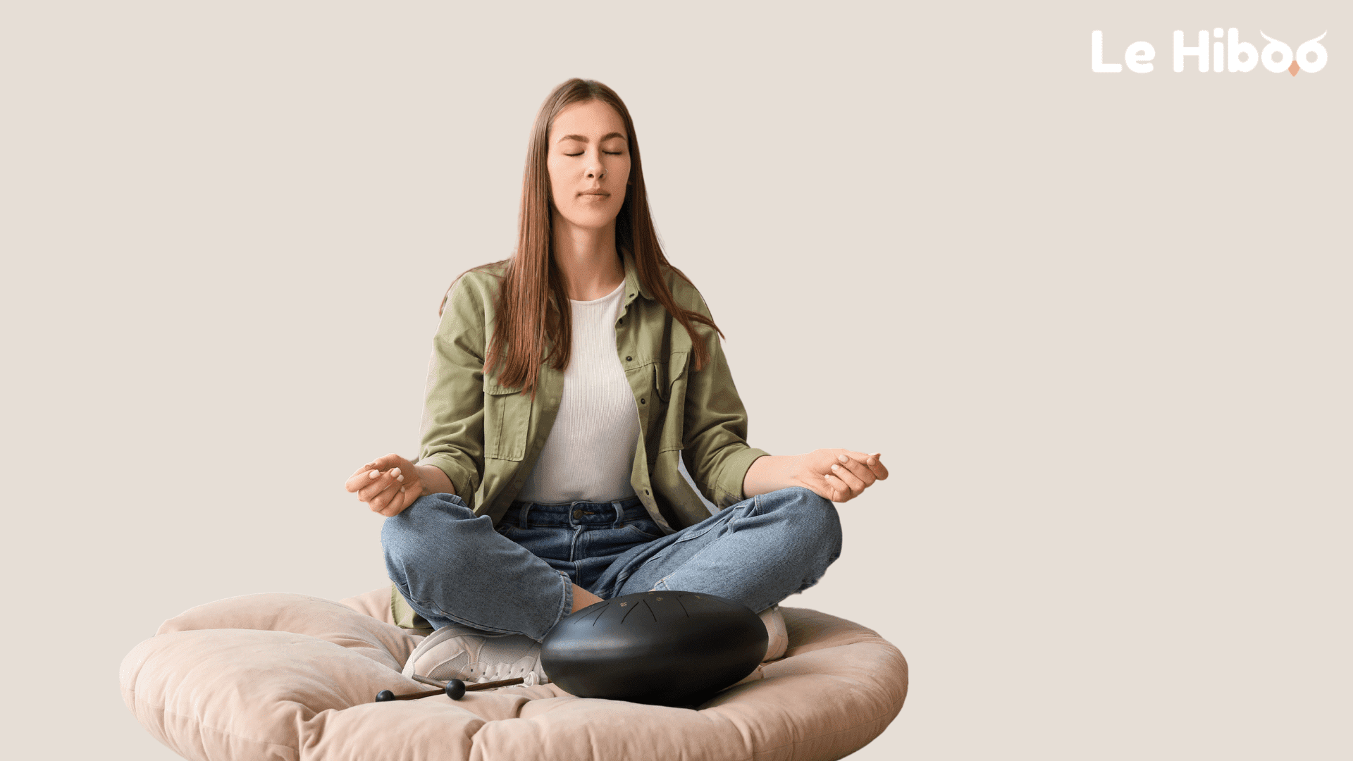 Femme meditant zen sur un pouf fond beige Femme meditant zen sur un pouf fond beige